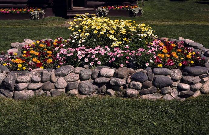 Очень красивые, надежные и долговечные бордюры для цветочной клумбы или декоративного цветника на придомовой территории получаются при использовании природного камня