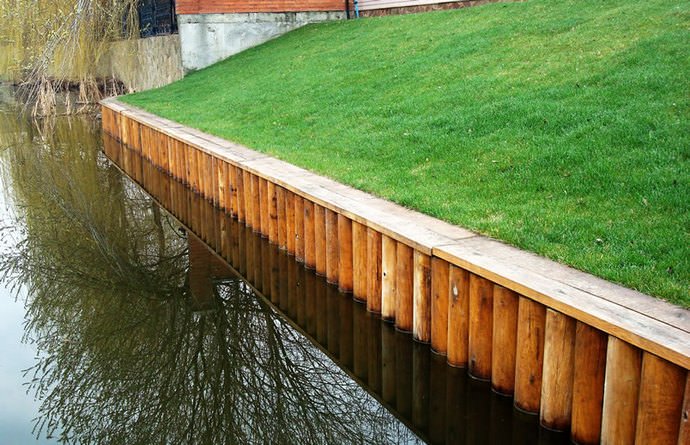 Метод укрепление береговой линии реки деревянными сваями относится к категории достаточно распространенных способов